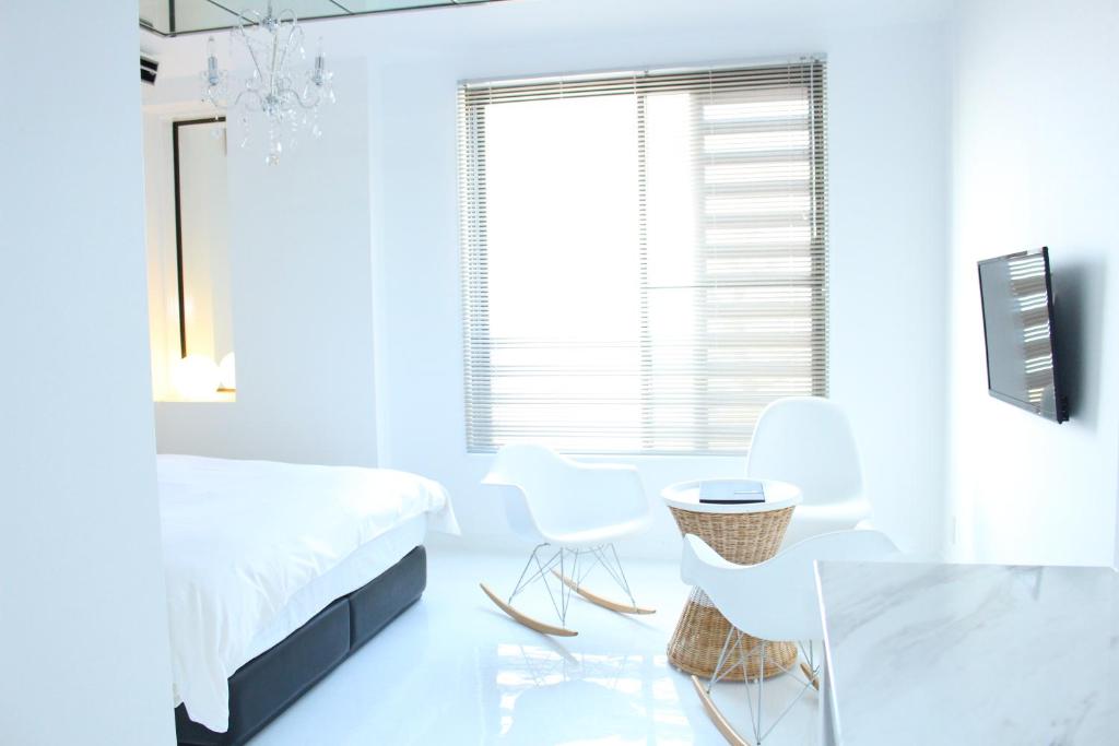 唐津汪洋海上风情度假酒店的白色卧室配有床和桌椅