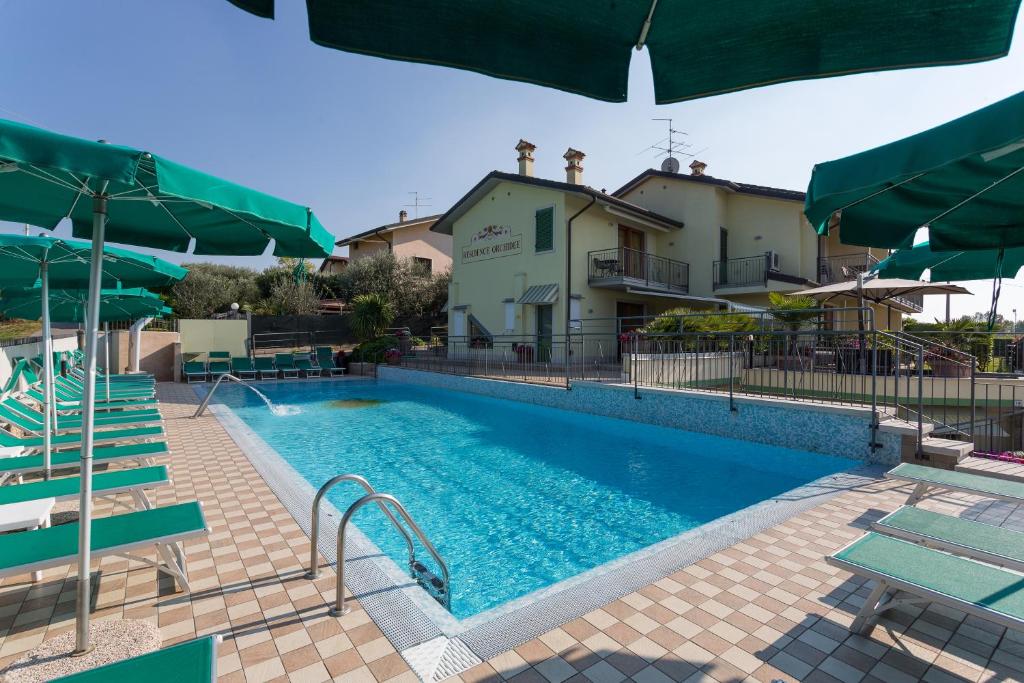 拉齐塞兰花公寓式酒店的一个带椅子和遮阳伞的大型游泳池