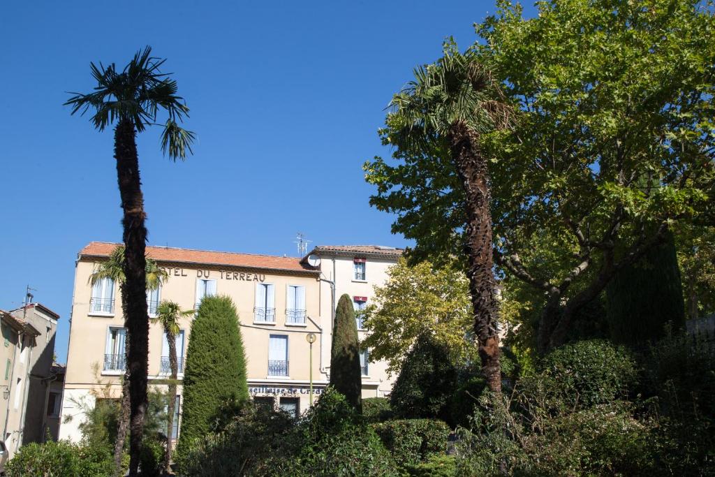 马诺斯克L'Hôtel du Terreau Logis de France的一座棕榈树建筑
