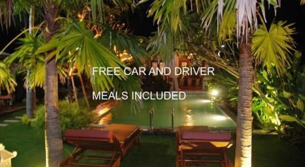 日惹罗瑟诺别墅的一间设有桌椅的餐厅,种植了棕榈树