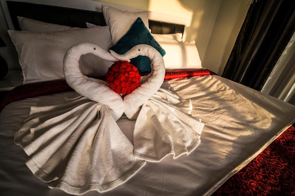 MawāliḩAl Mawaleh Furnished Flats & Rooms的一张床上有两条心形毛巾
