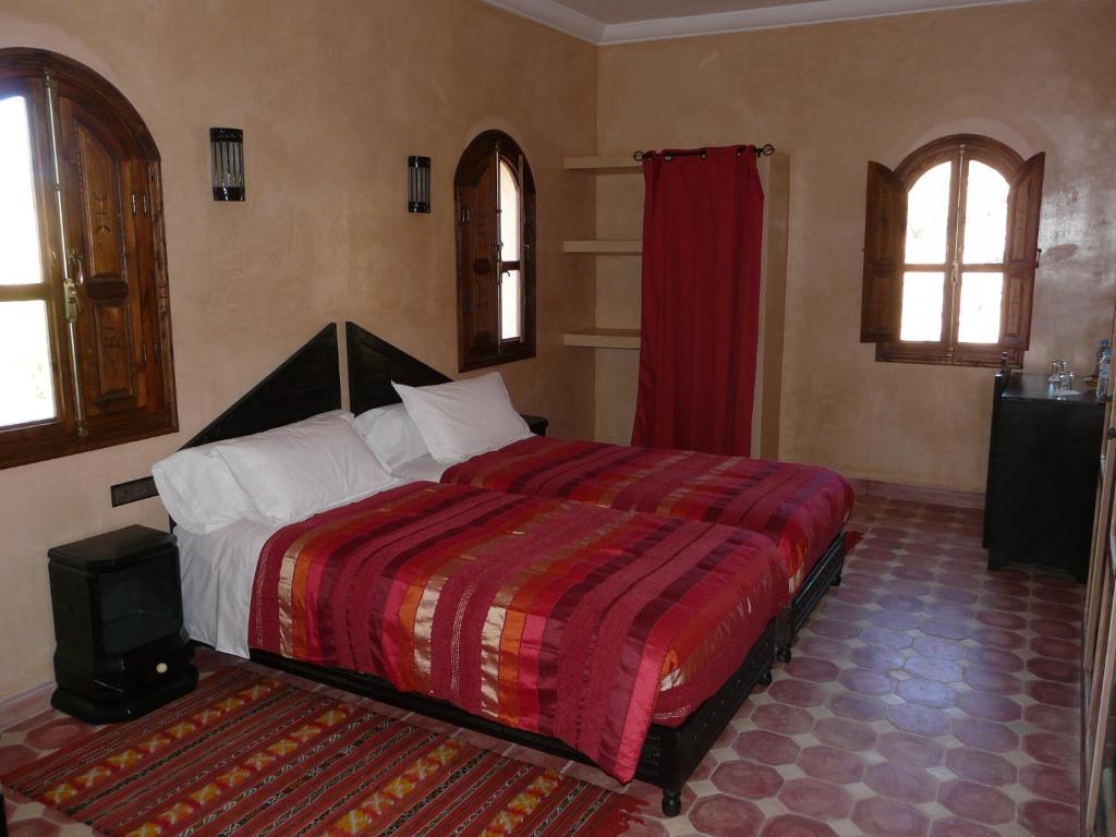 泰夫劳特Elmalara的一间卧室配有一张带红色毯子的大床