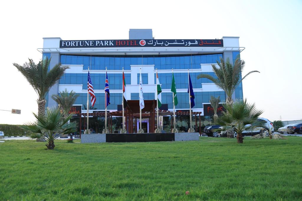 迪拜财富公园酒店 的前面草上挂着旗帜的建筑