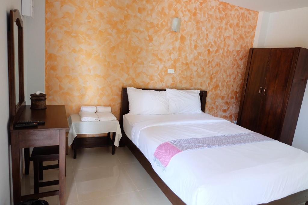 南府本雅酒店 的一间卧室配有两张床、一张桌子和一张书桌