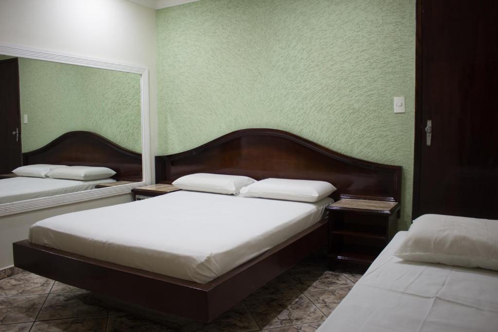 巴西利亚Hotel Valadares的绿墙客房内的两张床