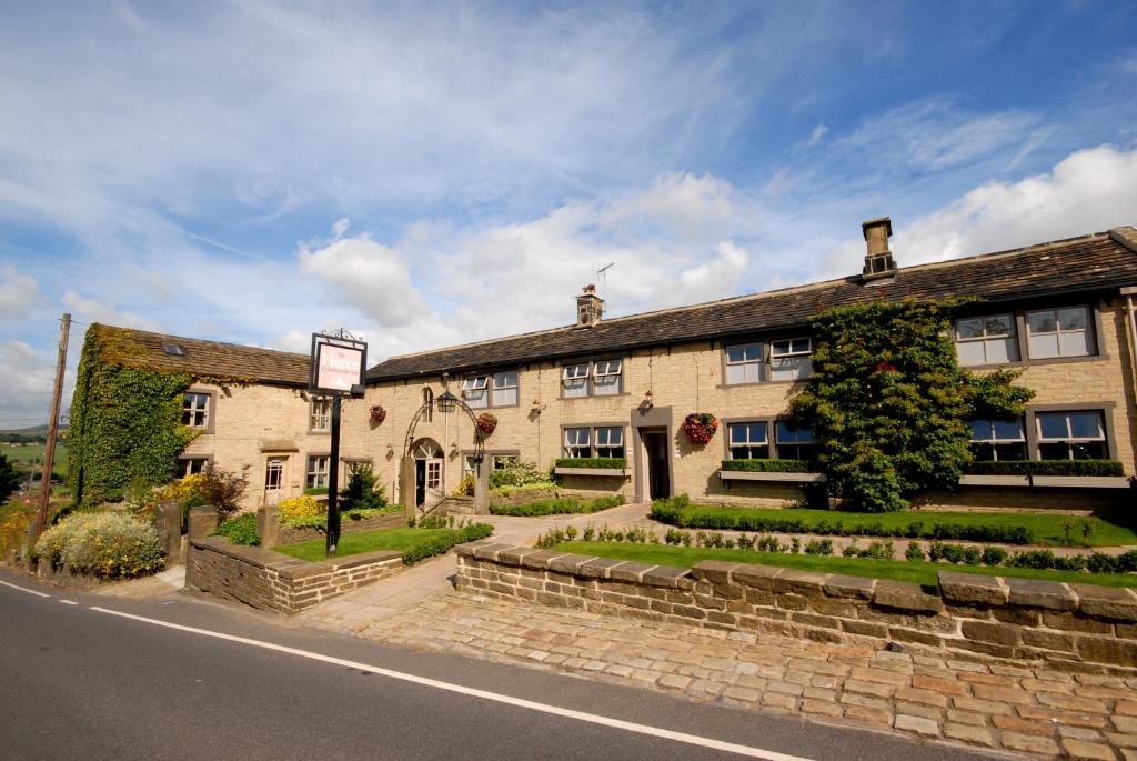 RippondenThe Fleece Inn at Barkisland的街道边的一座大型石头建筑