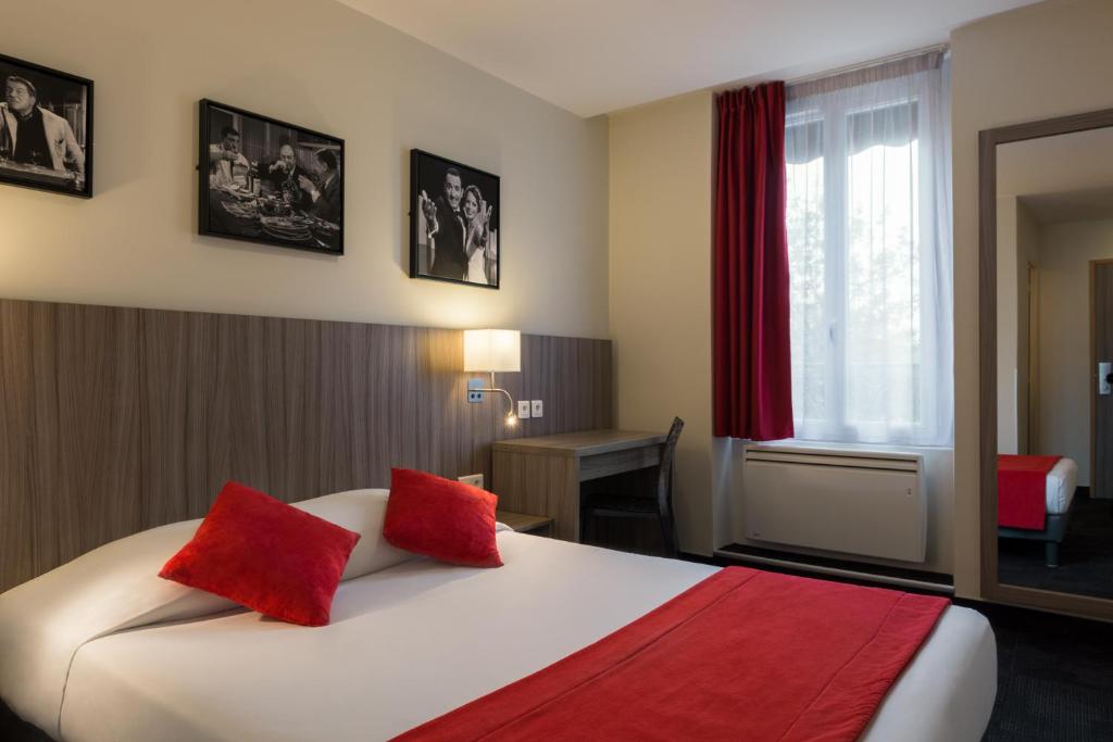 巴黎雷姆斯酒店的酒店客房配有一张带红色枕头的大床