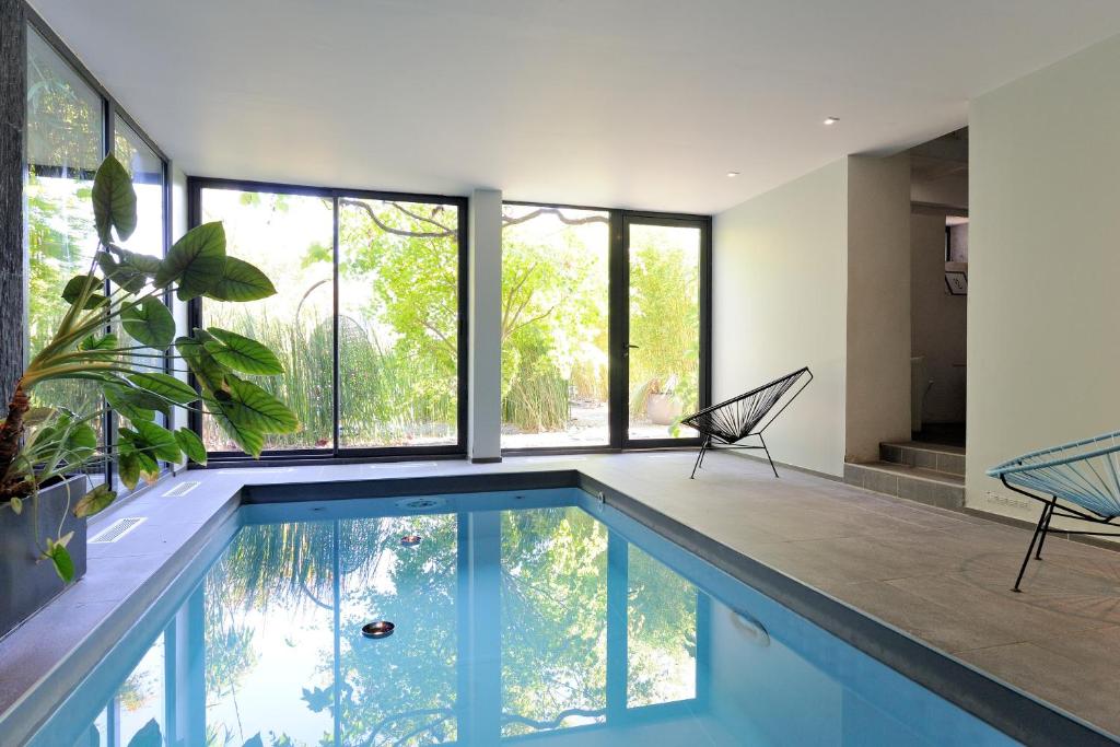 杜瓦讷内提伊马德酒店的一座带大窗户的房屋内的游泳池