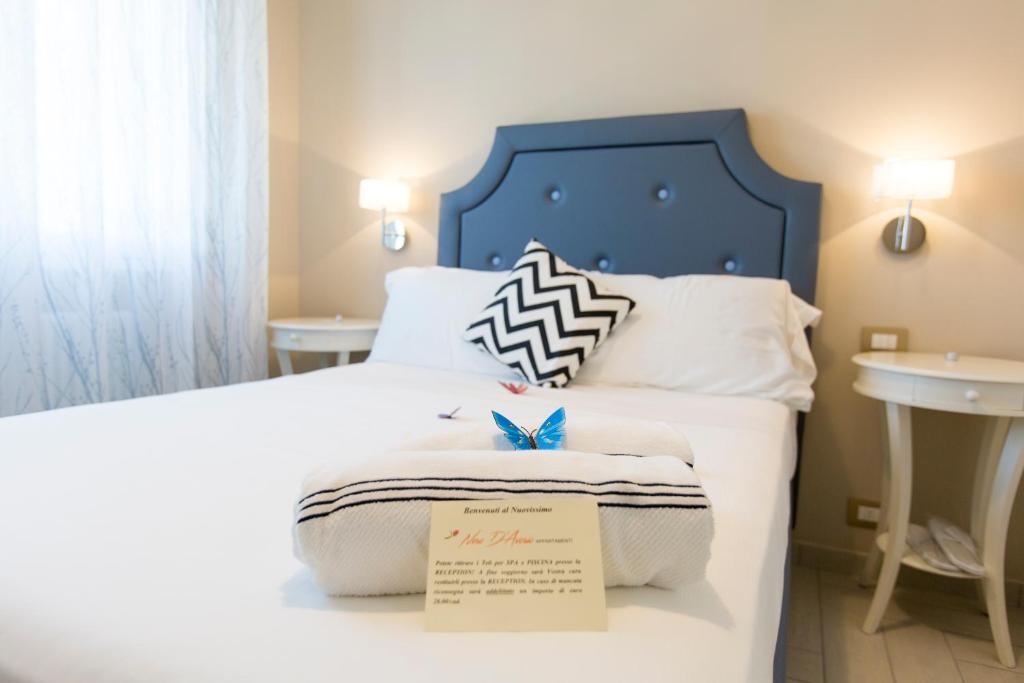 里米尼Nero D'Avorio Aparthotel & SPA的一张带蓝色床头板的床和床头标牌