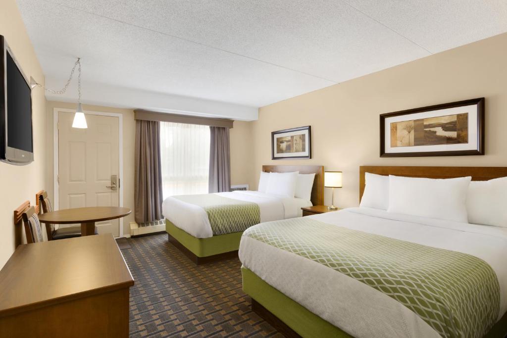 萨斯卡通殖民广场套房酒店的酒店客房设有两张床和一台平面电视。
