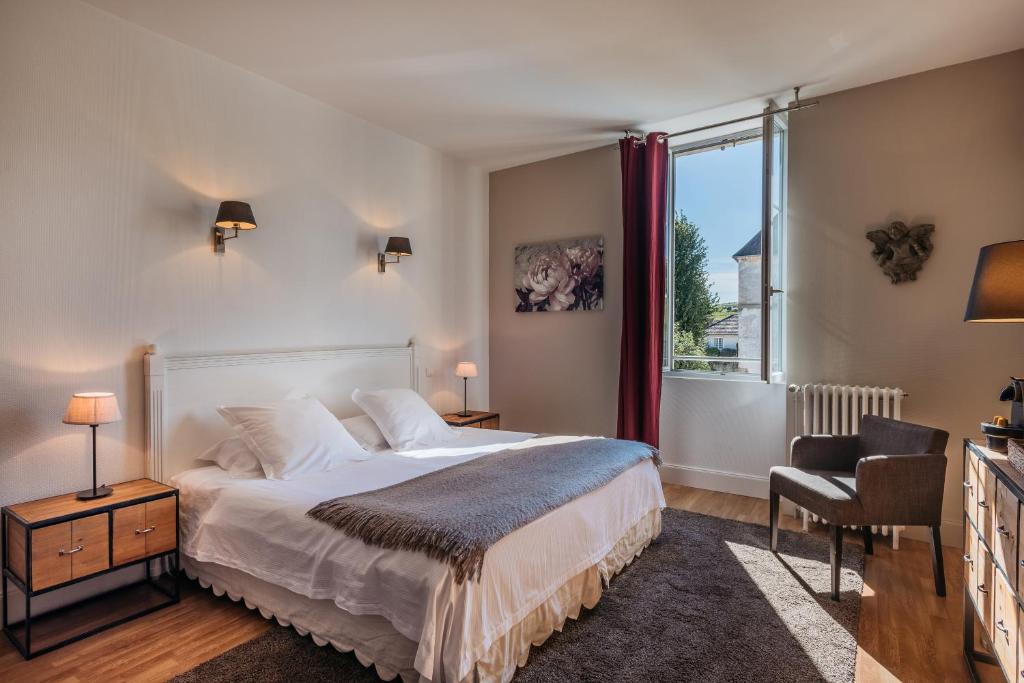波马尔Hôtel Le Clos du Colombier 1817 Vignes & Spa的一间卧室设有一张大床和一个窗户。