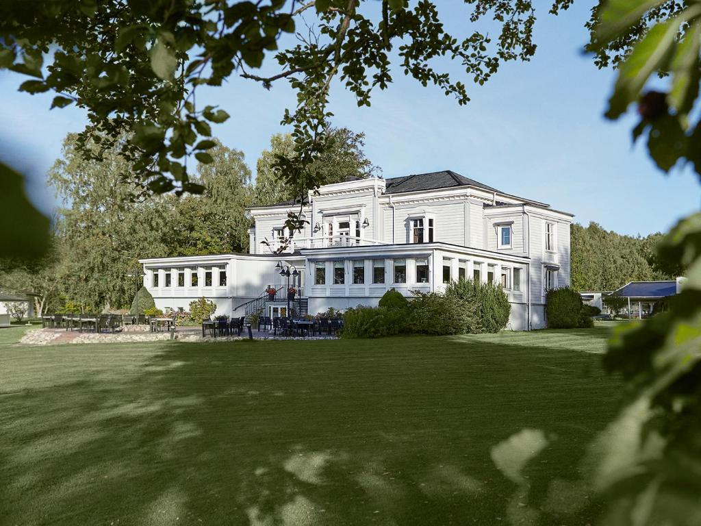 莱鲁姆Aspenäs Herrgård的一座大型白色房子,设有大院子