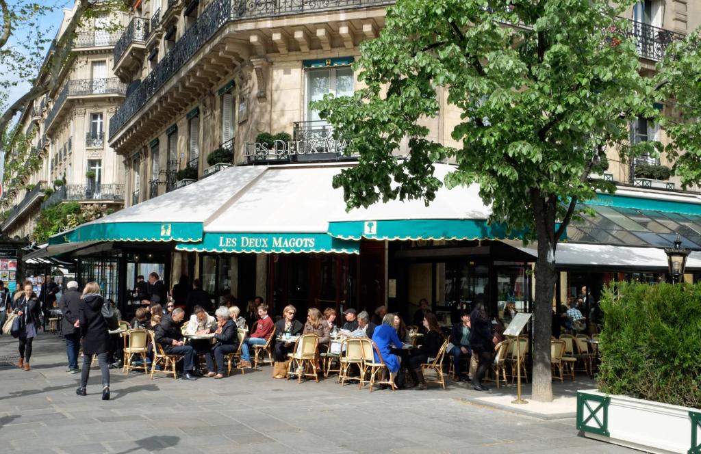 巴黎圣赫尔蒙巴克公寓的一群坐在餐厅外桌子上的人
