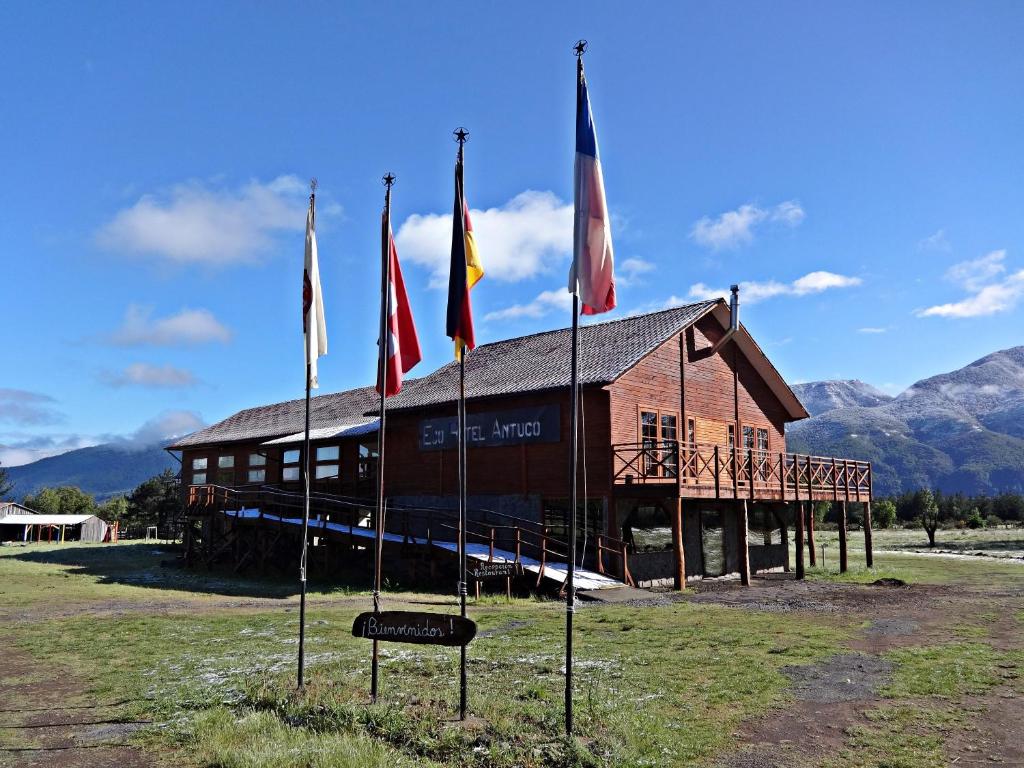 安图科Eco Hotel Antuco的前面有旗帜的建筑