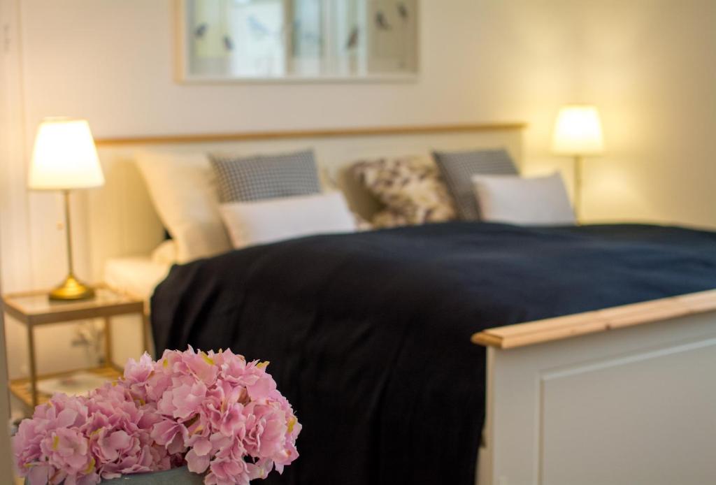 巴特萨尔茨乌夫伦Eulennest-OWL的一间卧室配有一张带黑色毯子和粉红色鲜花的床。