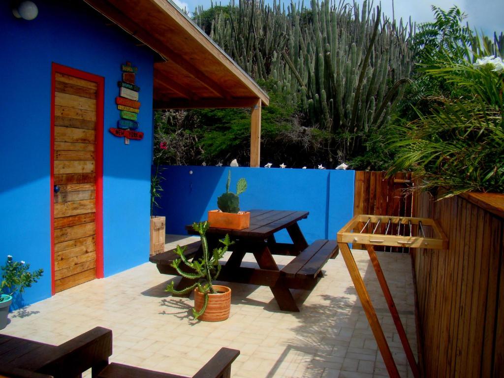 Santa CruzHopi Cadushi Apartment的庭院设有野餐桌和蓝色的墙壁