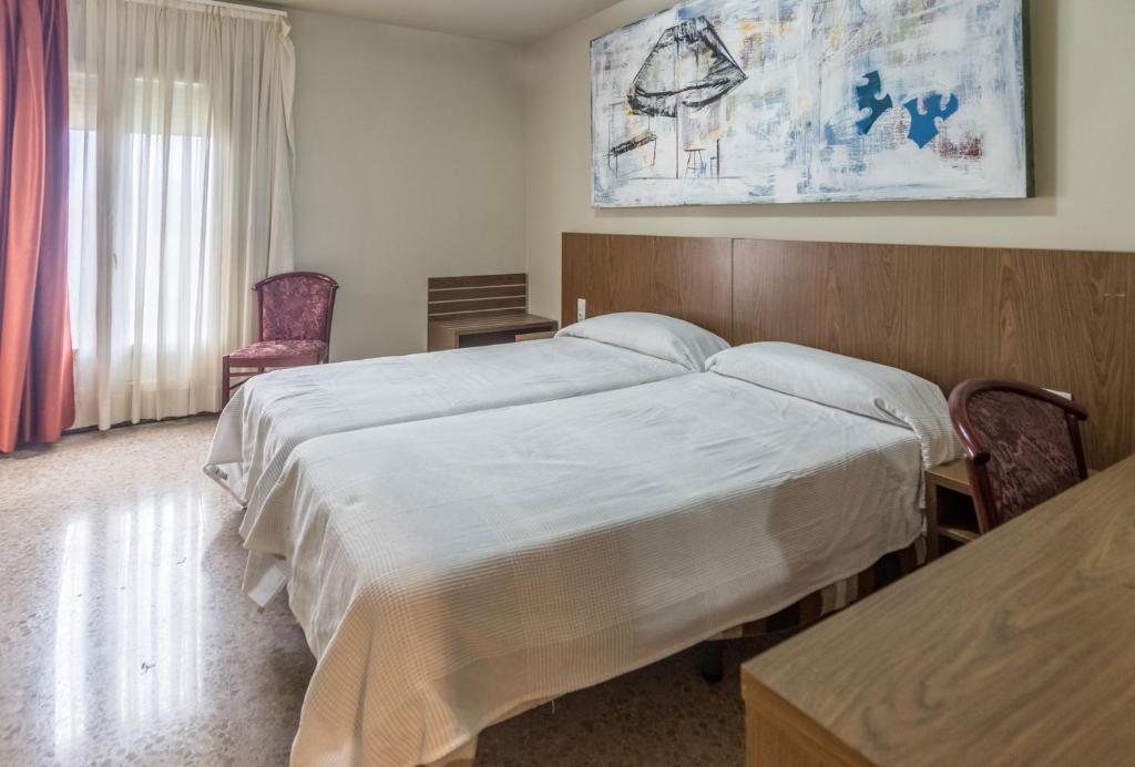 巴拉格尔Hostal Sant Miquel的一间卧室配有一张大床和木制床头板