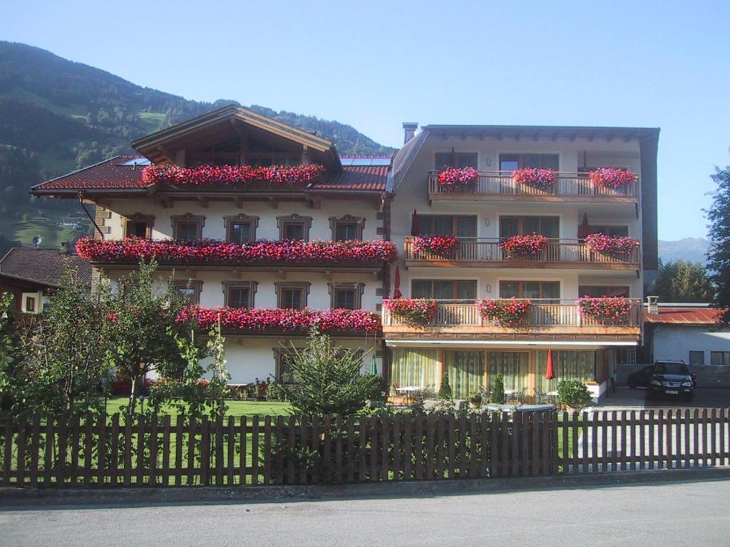 齐勒河谷采尔Hotel Garni Elisabeth的一座在阳台上装满红色鲜花的建筑