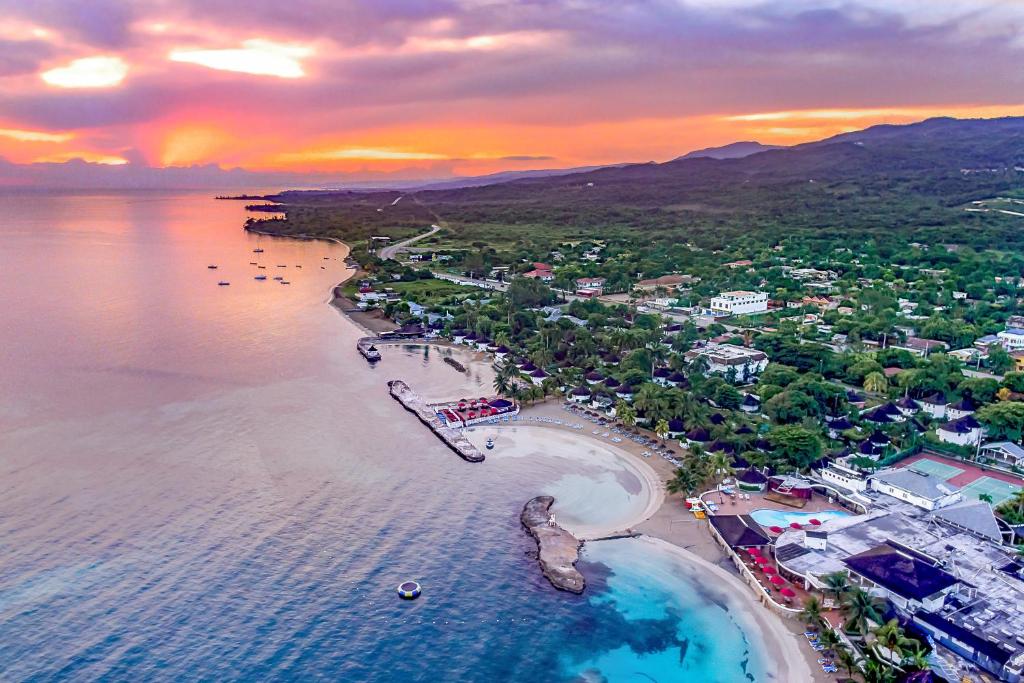 拉纳韦贝Decameron Club Caribbean Runaway Bay, Ramada All-Inclusive Resort的日落时分海滩空中景致