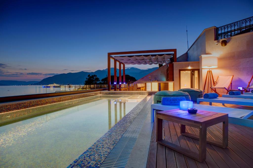 蒂瓦特拉罗什精品酒店的一座带游泳池和甲板上桌子的房子