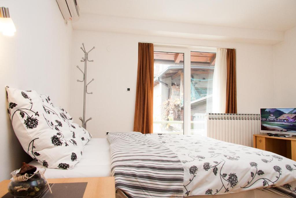 大戈里察花园客房旅馆的一间卧室设有一张床和一个窗口