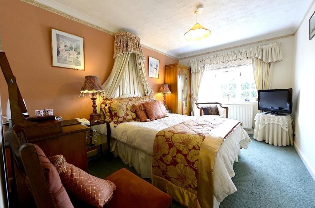 汤顿梅扬别墅酒店的一间卧室配有一张床和一台电视