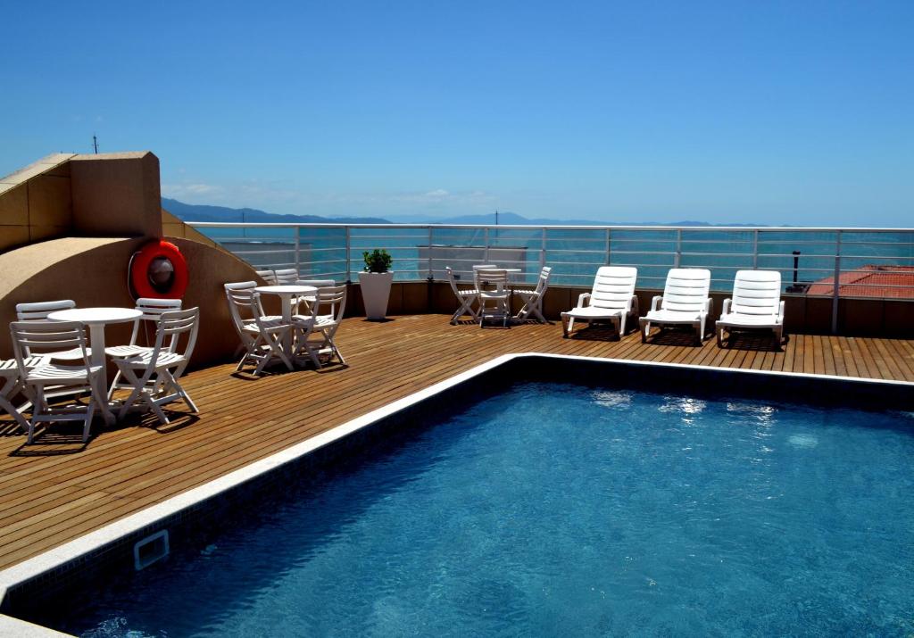 弗洛里亚诺波利斯路易莎皇宫酒店 的一个带游泳池、椅子和桌椅的甲板