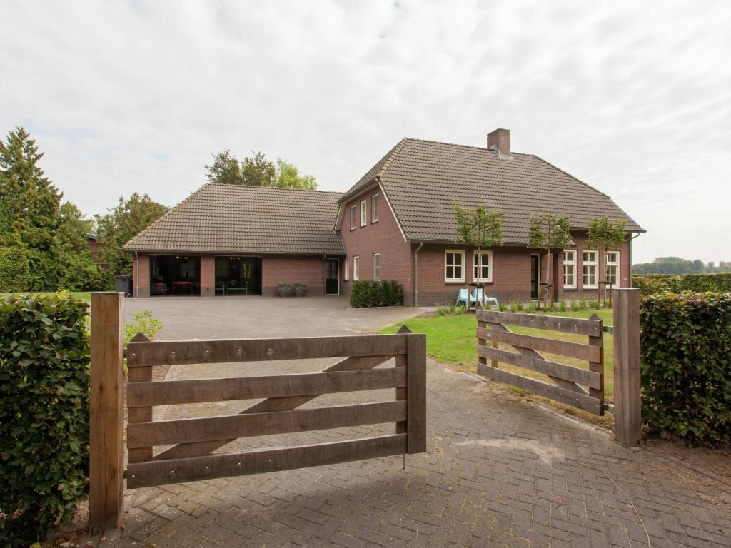 伦德Luxurious holiday home in the middle of the Leenderbos nature reserve, near quiet Leende的一座带木栅栏和车道的房子