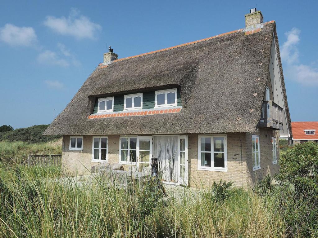 Midsland aan ZeeBeautiful villa on Terschelling in the dunes 150 meters away的一座带茅草屋顶的老砖屋