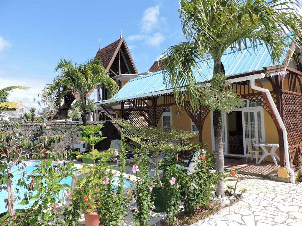 蓝海湾芙蓉别墅的一座带游泳池和棕榈树的房子