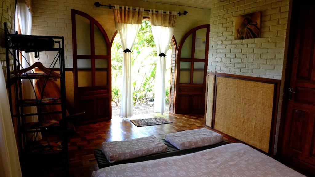 安齐拉贝Eco Lodge Les Chambres Du Voyageur的一间卧室设有一张床和一个开放式门
