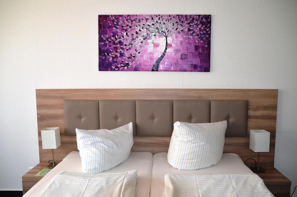 柏林波林公寓的一间卧室配有一张床铺,墙上挂着紫色绘画