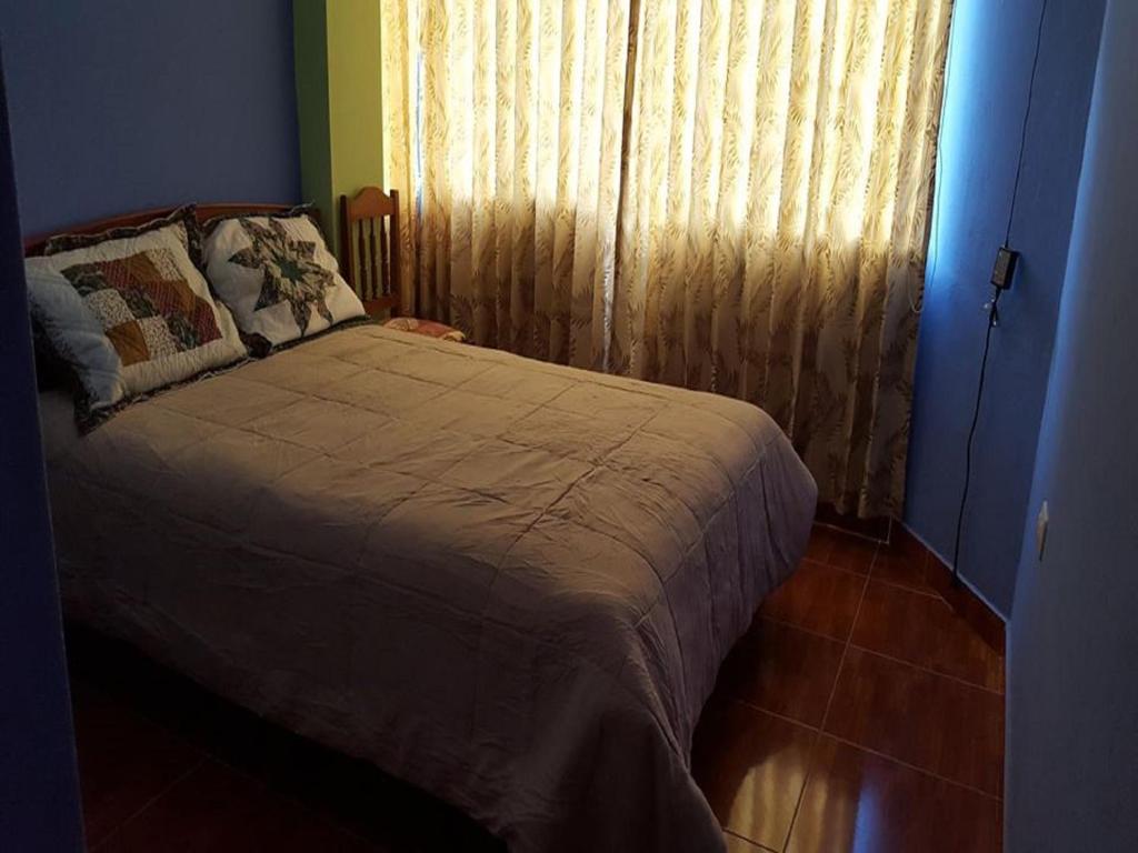 AbancayHostal Arcangel的一间卧室配有床和带窗帘的窗户