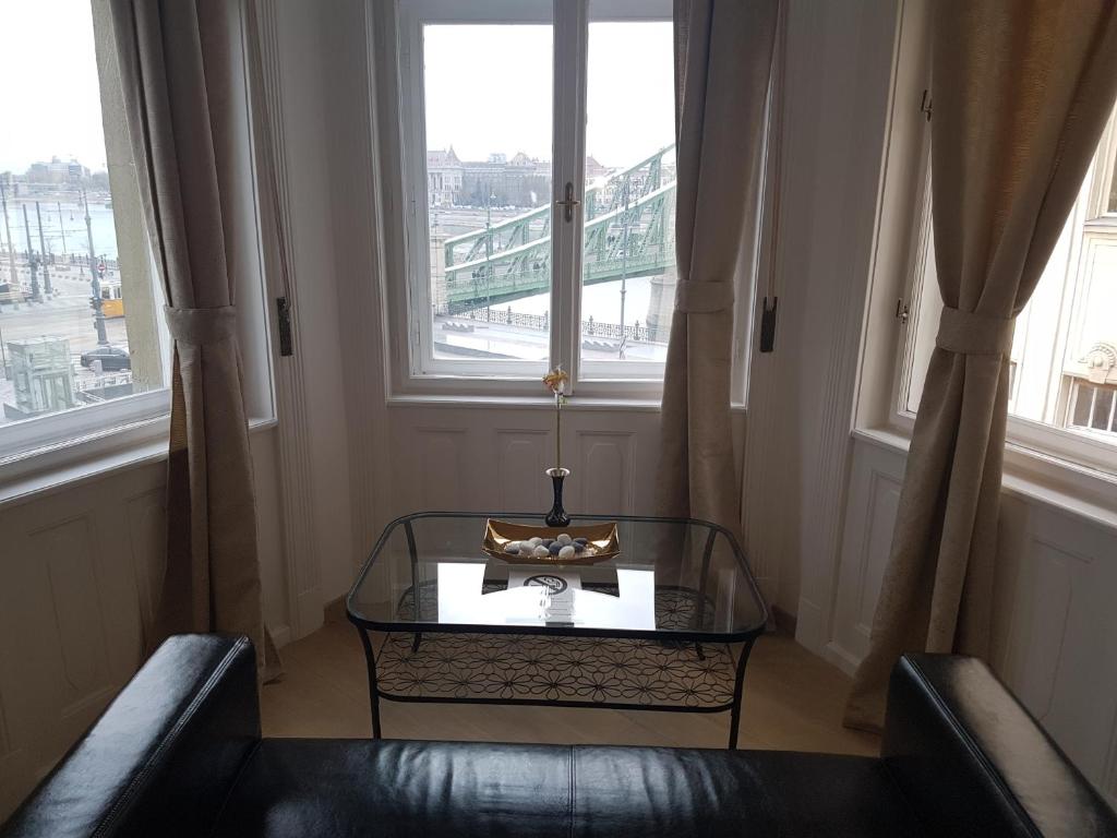 布达佩斯多瑙河蝴蝶之家住宿加早餐旅馆的一间设有桌子和两把椅子以及两个窗户的房间