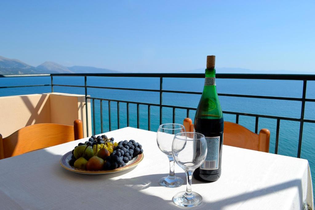 科帕罗Villa Panorma的一张桌子,上面放着一瓶葡萄酒和一碗水果