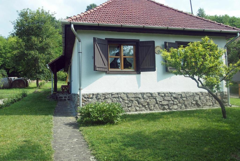 SzécsényOrgona Ház的一个小房子,设有窗户和石墙