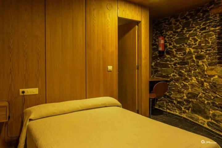 CasteloPalloza Baltasar的一间卧室设有一张床和石墙
