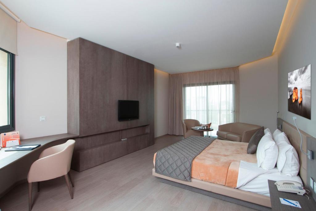 贝鲁特漫步酒店的酒店客房配有一张床、一张书桌和一台电视。