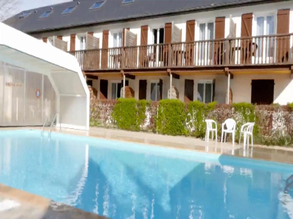 IzestAuberge de la Vallée d'Ossau的大楼前设有游泳池的酒店