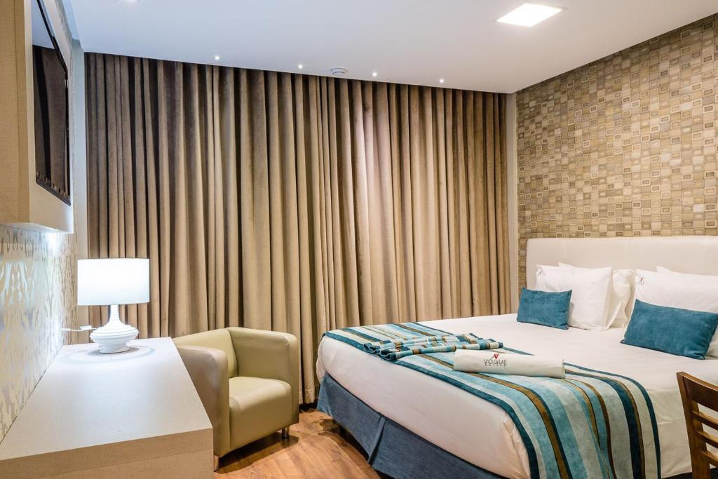 圣若昂迪梅里蒂里约热内卢时尚酒店的配有一张床和一把椅子的酒店客房