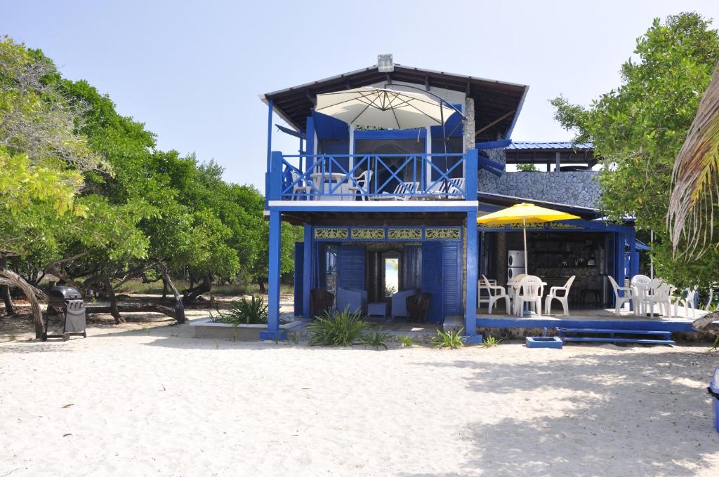 巴尔Casa Gaviota Baru Beach House的海滩上带桌椅的蓝色建筑