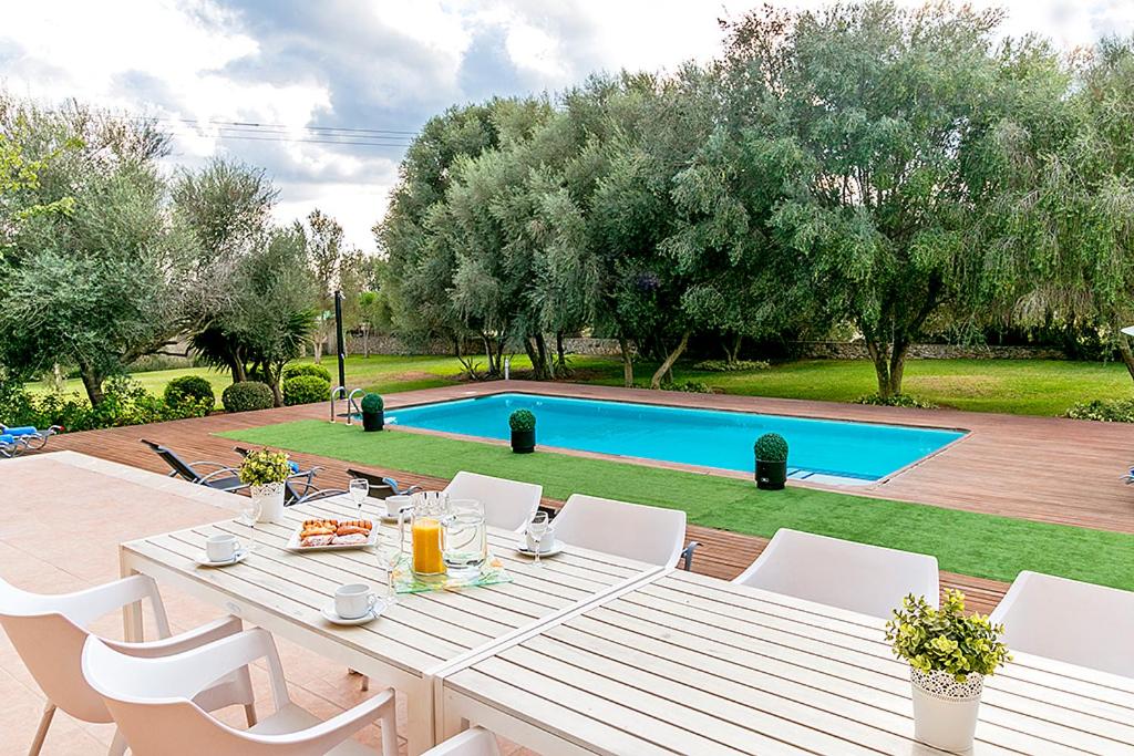 阿尔库迪亚芬卡圣玛丽亚度假屋的庭院里白色的桌椅,设有游泳池