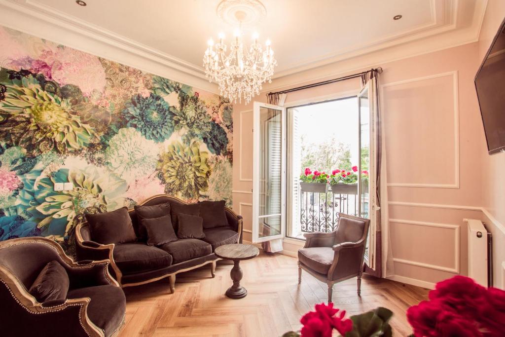 巴黎La Maison Gobert Paris Hotel Particulier的带沙发和花卉墙的客厅