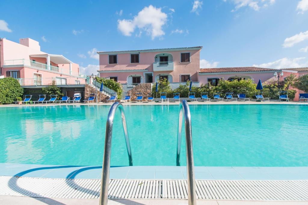 卡拉·利贝罗托Albergo Residenziale Gli Ontani的度假村内的一个蓝色海水游泳池