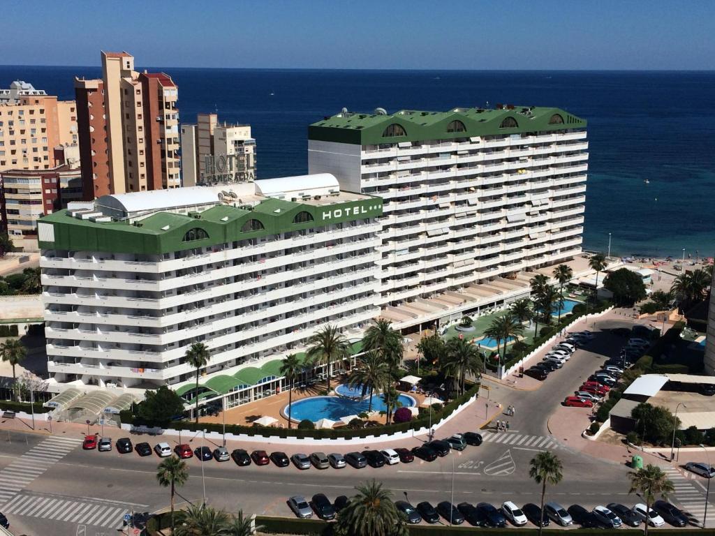卡尔佩AR Roca Esmeralda & SPA Hotel的大型酒店,在海洋前设有停车场