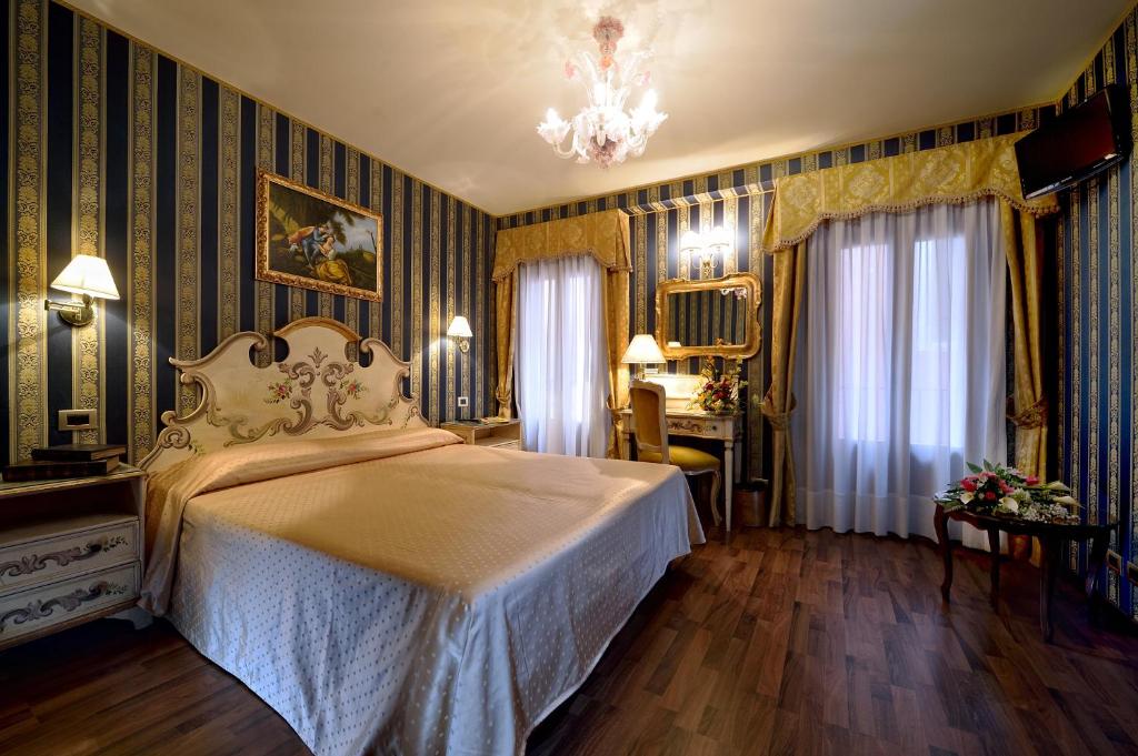 威尼斯米兰希塔迪酒店的一间卧室配有一张床和一个吊灯