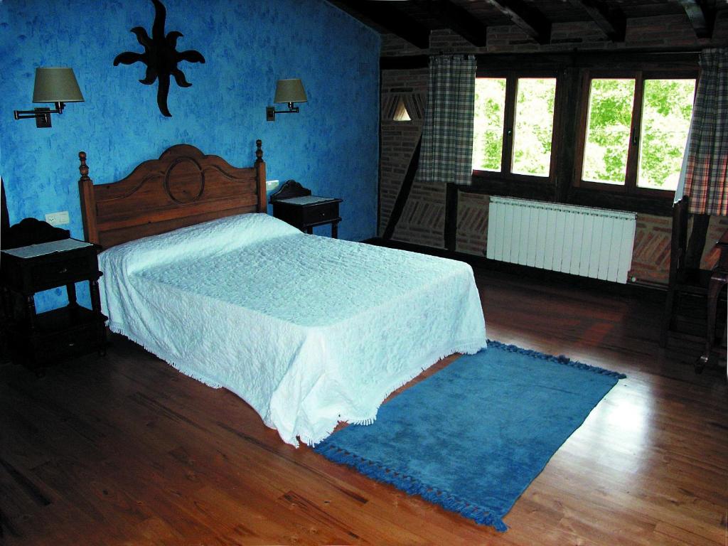 Ajangiz阿雷斯提耶塔酒店的一间卧室设有一张床和蓝色的墙壁