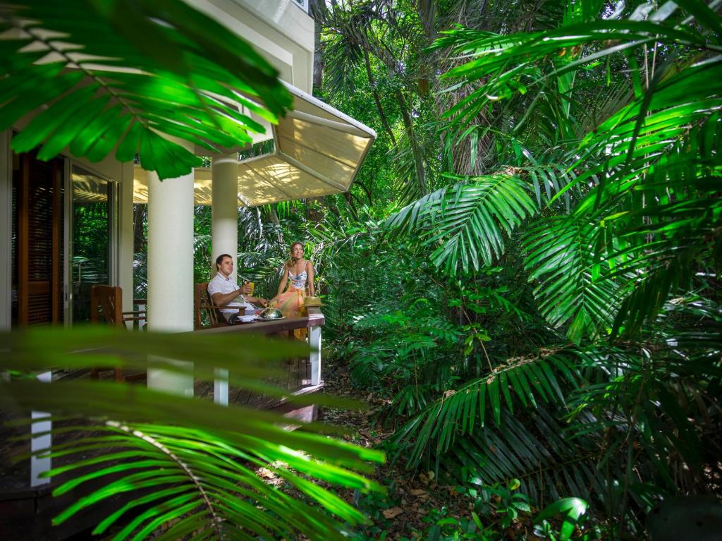 绿岛绿岛度假酒店的两个人坐在树屋的门廊上
