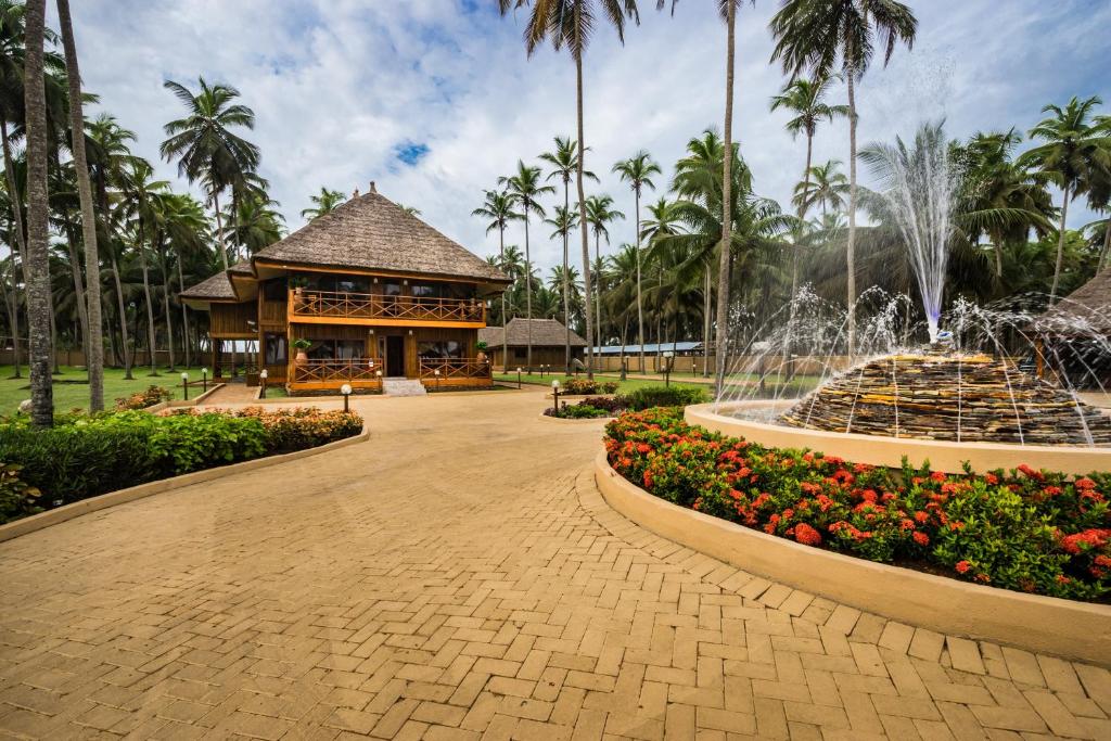 AnochiMaaha Beach Resort的棕榈树建筑前的喷泉