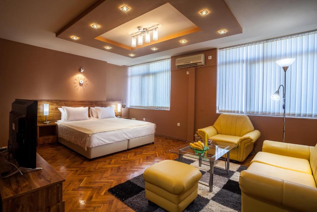 扬博尔Panorama Top Floor Rooms in Hotel Tundzha的一间卧室配有一张床、一台电视和一张沙发